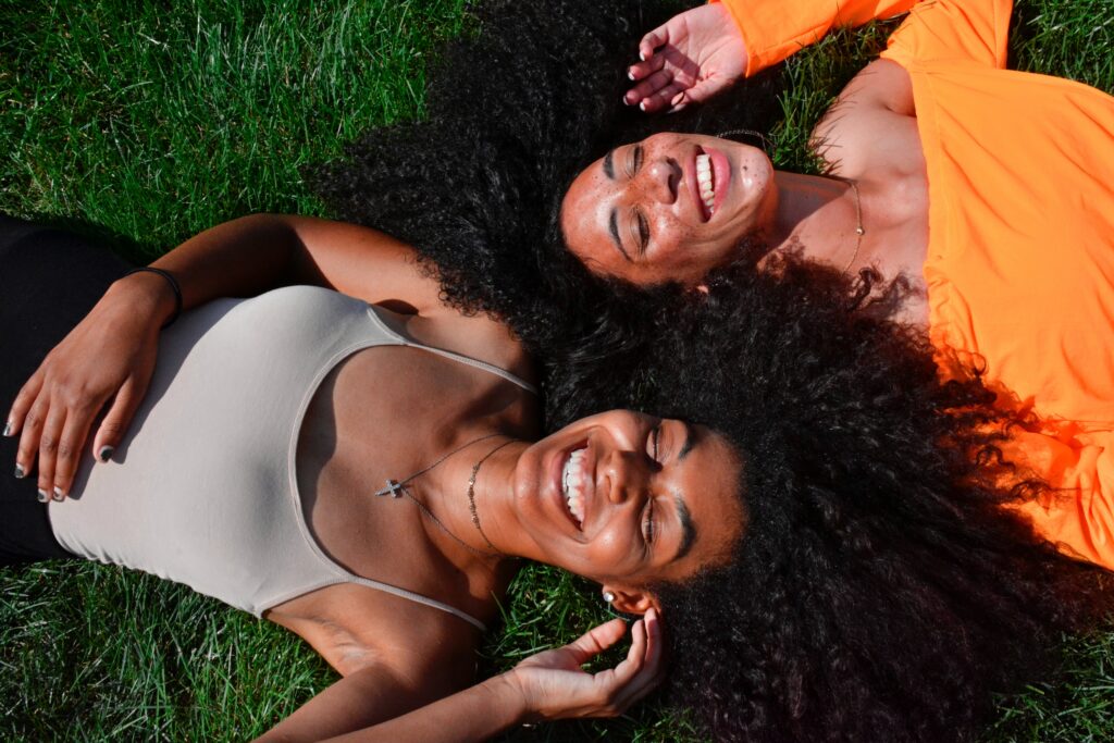 Two girls smiling while sunbathing